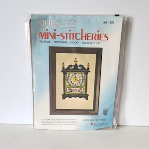 May include: A Bucilla Mini-Stitcheries embroidery kit for a colonial clock. The kit includes a pre-stamped linen fabric, embroidery floss, a needle, and instructions. The kit is labeled "Quick and Easy-to-Do" and is for a 7x9 inch project.