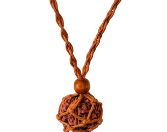 May include: A necklace featuring a textured, reddish-brown spherical seed encased in a light brown woven cord net. The pendant is topped with a smooth, round wooden bead and hangs from a twisted, light brown cord that extends upward.