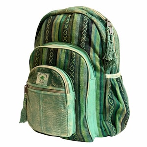 May include: Green and blue patterned backpack with multiple compartments. The backpack features a large main compartment, a smaller front pocket, and a smaller pocket on the front. The backpack has a zip closure and a tassel on the zip. The backpack is made of a woven fabric.