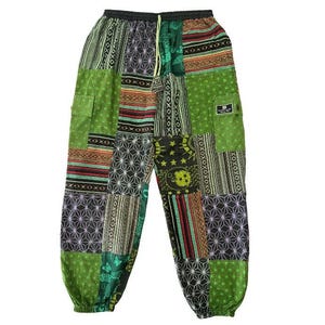 May include: Patchwork pants with a variety of patterns and colors, including green, black, and brown. The pants have a drawstring waist and a relaxed fit. The design features geometric shapes, stripes, and celestial motifs. There is a small pocket on the left leg.