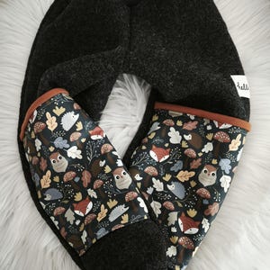 Op de afbeelding: Donkergrijze babybroek met manchetten met een bosdierenprint. De print bevat vossen, uilen, egels en paddenstoelen op een donkere achtergrond. De manchetten zijn afgezet met bruine stof. Het woord "hello" staat op een wit label.