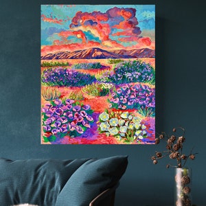 May include: A vibrant painting of a desert landscape with a colorful sunset sky. The foreground features a field of purple, pink, and white flowers. The background shows a mountain range and a cloudy sky.