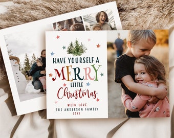 May include: Christmas greeting cards with family photos. One card features the text "Have Yourself a Merry Little Christmas" with colorful lettering and star accents. The cards are on a neutral background with dried plants.