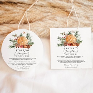 May include: Two white gift tags with a Christmas potpourri recipe. The tags feature a watercolor design of an orange slice, cinnamon sticks, and greenery. Text on the tags reads "Stovetop Christmas Potpourri" and instructions.
