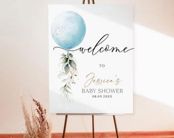 Puede incluir: Un letrero de bienvenida para un baby shower, exhibido en un caballete de metal. El letrero presenta una esfera azul acuarela, vegetación y las palabras "welcome to Jessica's BABY SHOWER 08.09.20XX" en escritura elegante. Arreglo floral seco en un jarrón.