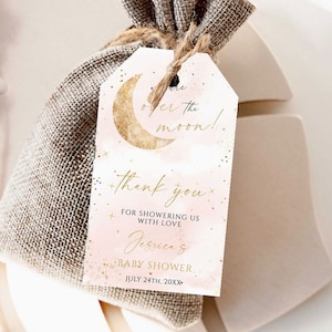Może przedstawiać: Różowa i złota karteczka z podziękowaniem na baby shower z półksiężycem i gwiazdami. Na karteczce napisano "Over the moon!" i "Dziękujemy za obdarowanie nas miłością Jessica's Baby Shower July 24th, 20XX".
