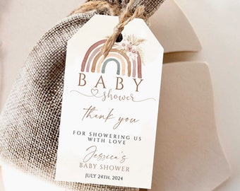 Op de afbeelding: Een wit bedankkaartje met een aquarel regenboog, bloemmotieven en de tekst "BABY shower thank you for showering us with love Jessica's Baby Shower July 24th, 2024".
