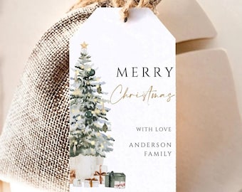 Könnte beinhalten: Ein weißes Geschenk-Etikett mit einem Aquarell-Weihnachtsbaum-Design und den Worten "MERRY Christmas" in goldener Schrift. Das Etikett ist an einem Jutesack mit einer Kordel befestigt. Die Worte "WITH LOVE" und "ANDERSON FAMILY" sind ebenfalls aufgedruckt.
