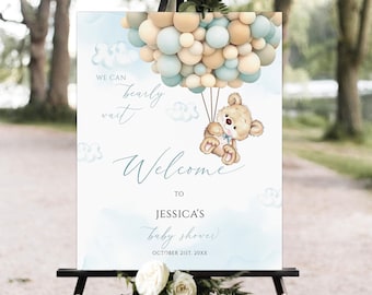 Könnte beinhalten: Ein Willkommenszeichen für eine Babyparty mit einem blauen und beigefarbenen Aquarellhintergrund. Ein Teddybär hält blaue und beigefarbene Ballons fest. Der Text lautet "We can barely wait" und "Welcome to Jessica's baby shower, October 21st, 20XX".