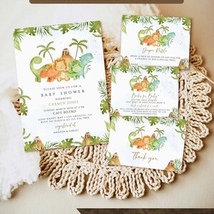 May include: A green, brown, and yellow baby shower invitation with a dinosaur theme. The invitation features a volcano, palm trees, and dinosaurs. The text on the invitation reads "Please join us for a baby shower honoring Carmen Jones".