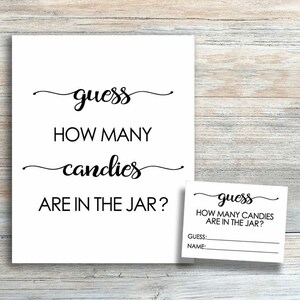 May include: A white sign with black text that reads "guess how many candies are in the jar?" with a smaller white sign with black text that reads "guess how many candies are in the jar? guess: name:"
