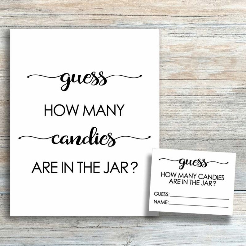 May include: A white sign with black text that reads "guess how many candies are in the jar?" with a smaller white sign with black text that reads "guess how many candies are in the jar? guess: name:"