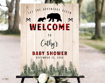 Puede incluir: Un cartel de bienvenida para un baby shower con un fondo de cuadros rojos y negros. El cartel presenta una silueta de una mamá oso y un bebé oso caminando. El texto dice "Let the adventure begin" y "Welcome to Cathy's Baby Shower December 12, 20XX".