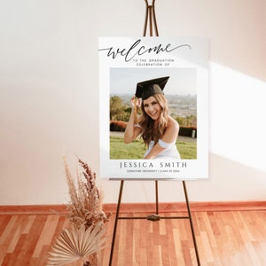 May include: Welcome to the graduation celebration of Jessica Smith, Signature University, Class of 20XX. A white sign with black text and a photo of a woman in a graduation cap and gown.