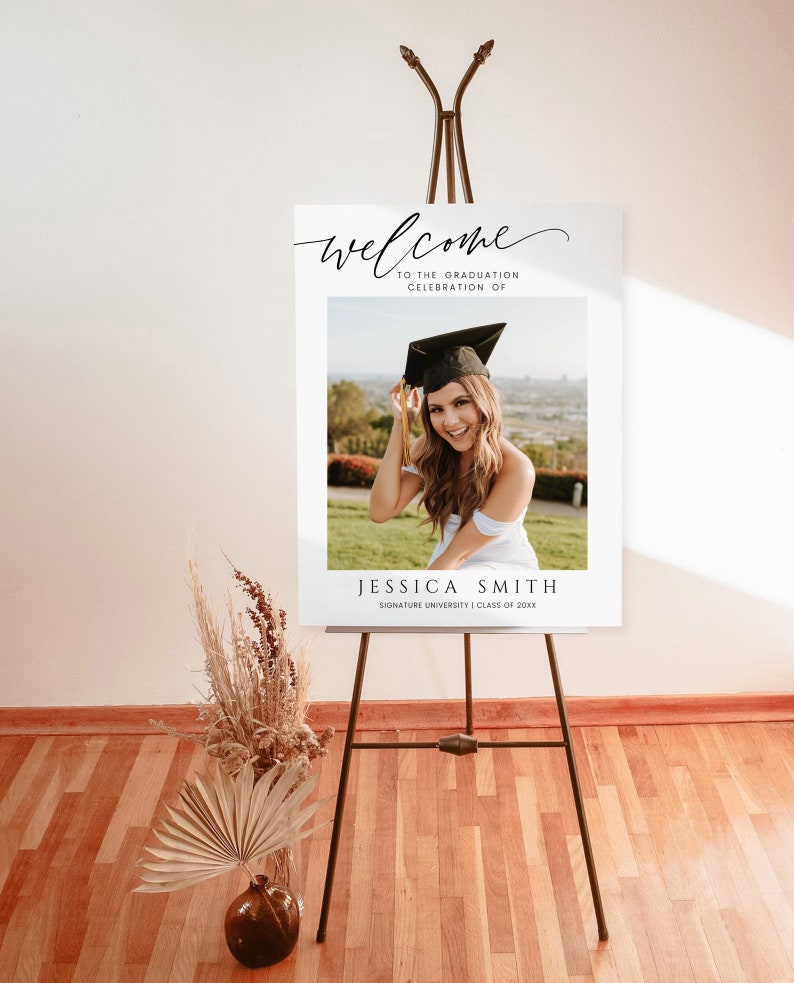 May include: Welcome to the graduation celebration of Jessica Smith, Signature University, Class of 20XX. A white sign with black text and a photo of a woman in a graduation cap and gown.