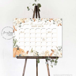 May include: A baby shower calendar sign on a wooden easel. The sign features the text "Guess the arrival date of BABY JACK" with a calendar grid. Floral and pumpkin illustrations decorate the edges. The sign is white with gold and brown accents.