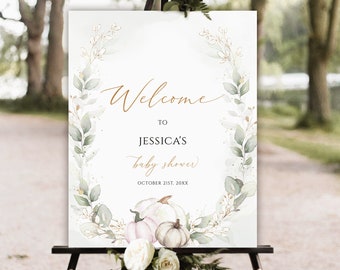 Könnte beinhalten: Ein rechteckiges Willkommensschild für eine Babyparty mit dem Text Welcome to Jessica's baby shower October 21st, 20xx. Das Design zeigt einen Aquarellkranz aus grünen Blättern und goldenen Akzenten mit drei Kürbissen am unteren Rand.