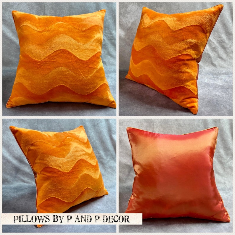 K&ouml;nnte beinhalten: Vier dekorative Kissen, zwei in leuchtendem Orange mit einem wellenf&ouml;rmigen Muster und zwei in einfarbiger orange-roter Farbe. Die Kissen sind in einem Raster auf einer hellgrauen Oberfl&auml;che angeordnet. Der Text "PILLOWS BY P AND P DECOR" ist am unteren Rand des Bildes gedruckt.
