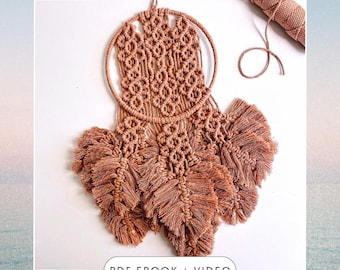 May include: A brown macrame wall hanging with a circular base and multiple fringe tassels. The hanging is made with a natural fiber cord and has a geometric pattern. The text "PDF EBOOK + VIDEO" is at the bottom of the image.