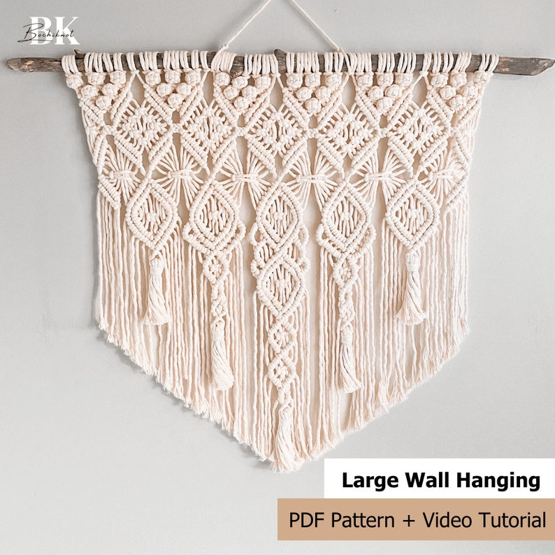 Pu&ograve; includere: Un grande arazzo da parete in macram&egrave; con un motivo geometrico di colore crema. L'arazzo &egrave; realizzato con cordoncino di cotone e ha un'asta di legno nella parte superiore. Il testo "Large Wall Hanging" e "PDF Pattern + Video Tutorial" &egrave; nella parte inferiore dell'immagine.