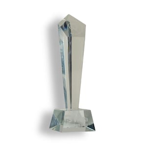 May include: A clear, faceted glass award trophy with a tall, tapered body and a wide, trapezoidal base. The top features an etched outline of a tooth, while the base displays the text 'pro vista' and 'DENTISTRY LIGHT' in white lettering.