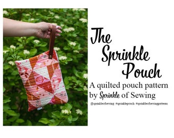 Op de afbeelding: Een gestikt taspatroon genaamd "The Sprinkle Pouch" van Sprinkle of Sewing. De tas is roze, rood en wit met een bruin leren handvat.  #sprinkleofsewing #sprinklepouch #sprinkleofsewingpatterns