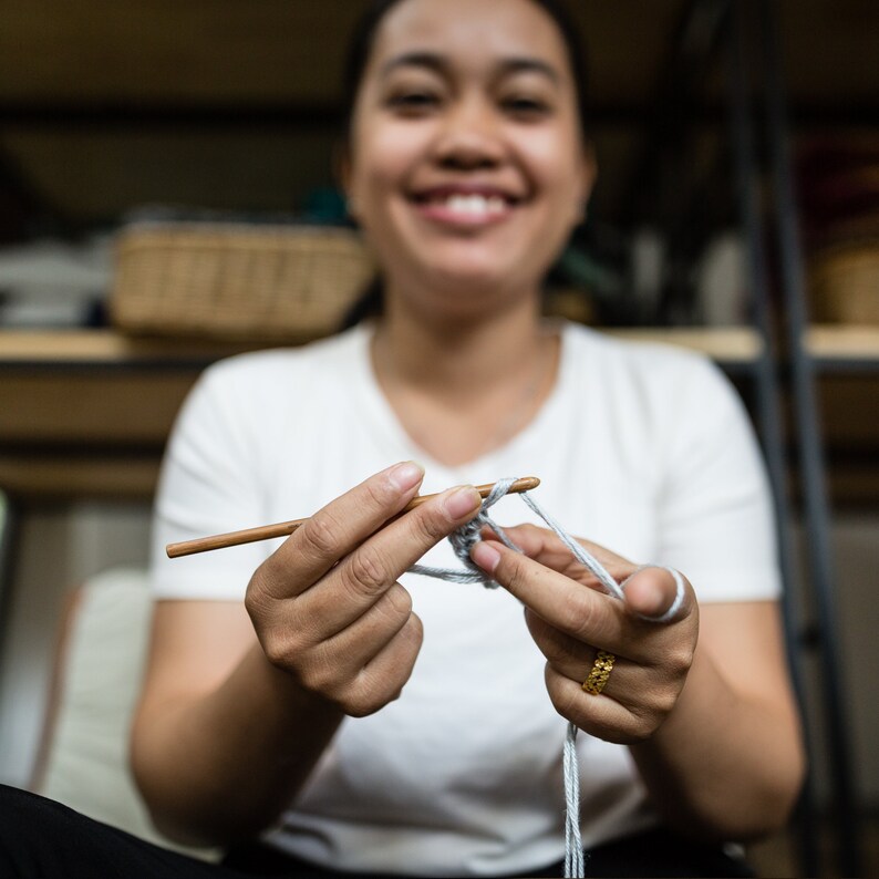 Smiling woman crochetting