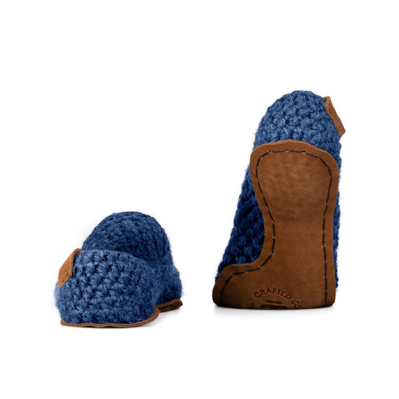 Peut inclure: Deux chaussons bleus en crochet avec des d&eacute;tails en cuir marron. Les chaussons sont faits d'un mat&eacute;riau en tricot &eacute;pais et comportent un patch en cuir sur le talon. Les chaussons sont con&ccedil;us pour un usage int&eacute;rieur.
