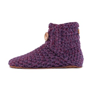 A lavender purple hand knitted slipper boot with a wooden button closure. The slipper has a thick, textured knit and a leather sole. Barefoot slippers for indoor use. Warm, cozy and comfortable. Perfect loungewear.