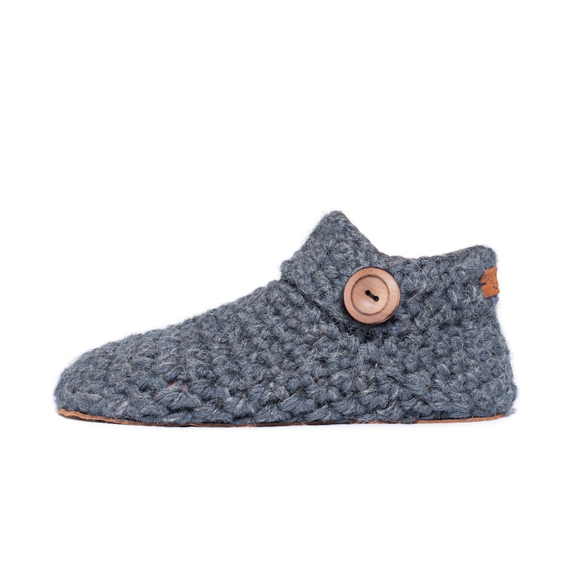Side angle of a dark gray wool slipper with wooden button fastening and suede leather sole. Handmade by Kingdom of Wow. Barefoot design for Men and Women.