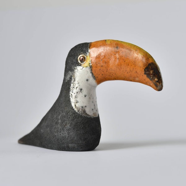 Figurine d'oiseau gris foncé en céramique, poterie raku, gorge blanche et bec orange. Toucan. Sculpture en céramique