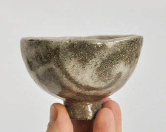 Raku pottery chawan. Brown and white tea bowl with goldish shine in places.