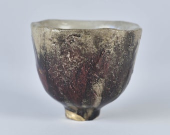 Raku pottery chawan. Light grey dark brown, and red copper smears. With kintsugi on the food.