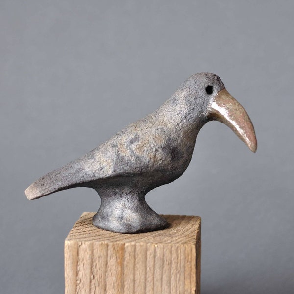 Céramique raku gris corbeau avec un bec brun brillant et des craquelures. Figurine d'oiseau. Sculpture en céramique. Poterie raku.