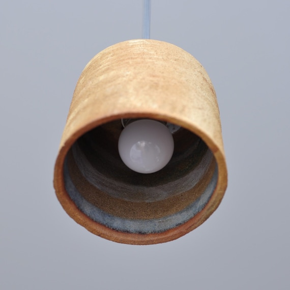 A raku-fired ceramic pendant lamp with a glazed interior — raku is an unpredictable, labor-intensive Japanese firing technique that makes every single piece a one-of-a-kind art object, and 45 favorites confirm people feel the same way.