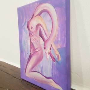 May include: An oil painting on canvas depicts a surreal figure with a swan-like neck and head, rendered in shades of pink and purple. The artwork is set against a lavender background, with visible brushstrokes adding texture. The canvas is displayed at an angle, showcasing its depth.