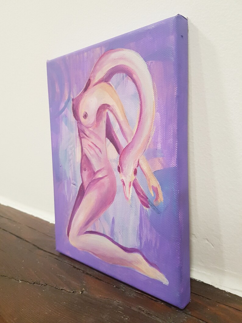 May include: An oil painting on canvas depicts a surreal figure with a swan-like neck and head, rendered in shades of pink and purple. The artwork is set against a lavender background, with visible brushstrokes adding texture. The canvas is displayed at an angle, showcasing its depth.