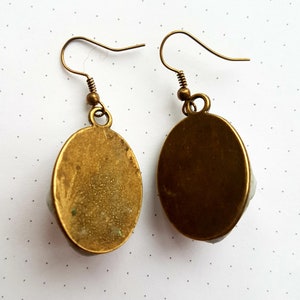 May include: A pair of oval-shaped earrings with a gold finish. The earrings have a simple design and are perfect for everyday wear.