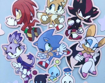 May include: A set of nine colorful cartoon character stickers featuring Sonic the Hedgehog, Tails, Knuckles, Shadow, Amy Rose, and others. The stickers are printed on white paper and have a glossy finish.
