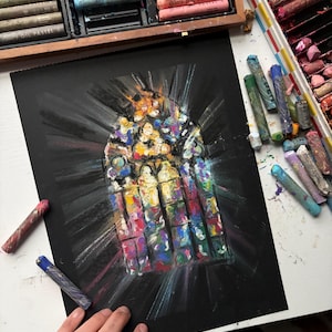 May include: An oil pastel drawing on black paper depicting a vibrant, multi-coloured stained glass window with radiating light beams. The artwork is surrounded by open wooden boxes filled with various colourful oil pastel sticks.