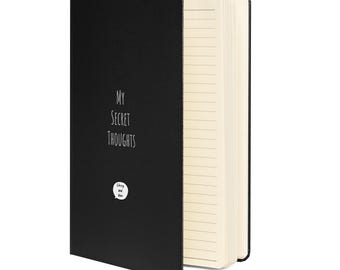May include: A black notebook with the text "My Secret Thoughts" on the front cover. The notebook has a lined interior and a small sticker with the text "Crazy and Wise" on the front cover.