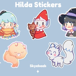 May include: A set of five die-cut stickers titled Hilda Stickers and Skyebeeb, featuring cartoon illustrations of a blue-haired character with flowers, a red-hooded figure holding a brown cat, a witch, a peach-colored creature, and a white fox.