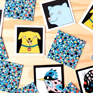 Peut inclure: Plusieurs impressions d'art carr&eacute;es avec des illustrations fantaisistes. Les impressions pr&eacute;sentent des motifs color&eacute;s, notamment des chiens de dessins anim&eacute;s, des oiseaux et des motifs abstraits &agrave; pois. Les impressions sont pos&eacute;es sur un fond en bois clair.