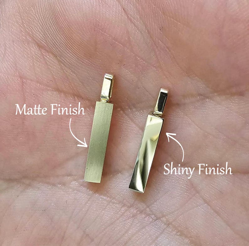 May include: Two gold-coloured rectangular bar pendants with attached bails. The left pendant features a matte finish, while the right pendant features a shiny, reflective finish. Text labels indicate Matte Finish and Shiny Finish with arrows.