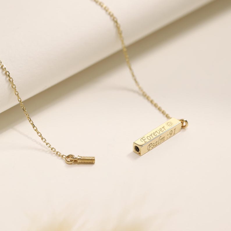 May include: Gold chain necklace with a small rectangular pendant engraved with "Forever Psalm 91".