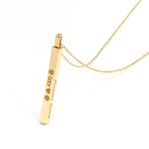 May include: A gold-toned vertical bar pendant necklace featuring an engraved design with the name Izzy, a heart symbol, two paw prints, and the text forever loved. The pendant hangs from a delicate matching gold-toned chain link necklace.