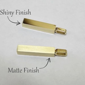 May include: Two gold-coloured rectangular bar pendants with attached bails. The top pendant features a shiny finish, while the bottom pendant has a matte finish. Text labels indicate Shiny Finish and Matte Finish for each respective pendant.