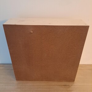 Puede incluir: Una caja de madera con una superficie marr&oacute;n texturizada. La caja tiene una tapa de madera clara y est&aacute; hecha de madera maciza.