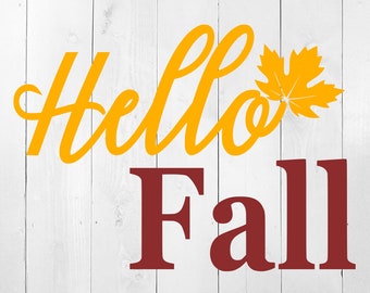 Könnte beinhalten: Ein weißer Holzgrund mit den Worten "Hello Fall" in gelber und kastanienbrauner Schrift. Rechts neben dem Wort "Hello" befindet sich ein gelbes Blatt.