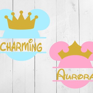 May include: Two split monogram designs featuring a blue and pink Mickey Mouse head with a gold crown on top. The blue design says "CHARMING" and the pink design says "AURORA".